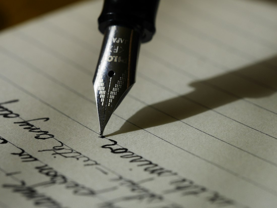 Open notebook and editorial writing materials on a desk
